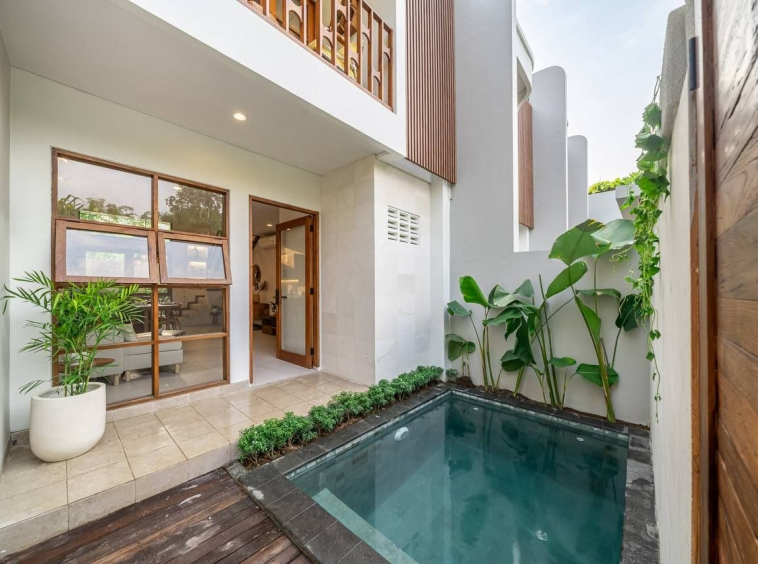 Two-storey villa facade with timber louvres and a private pool