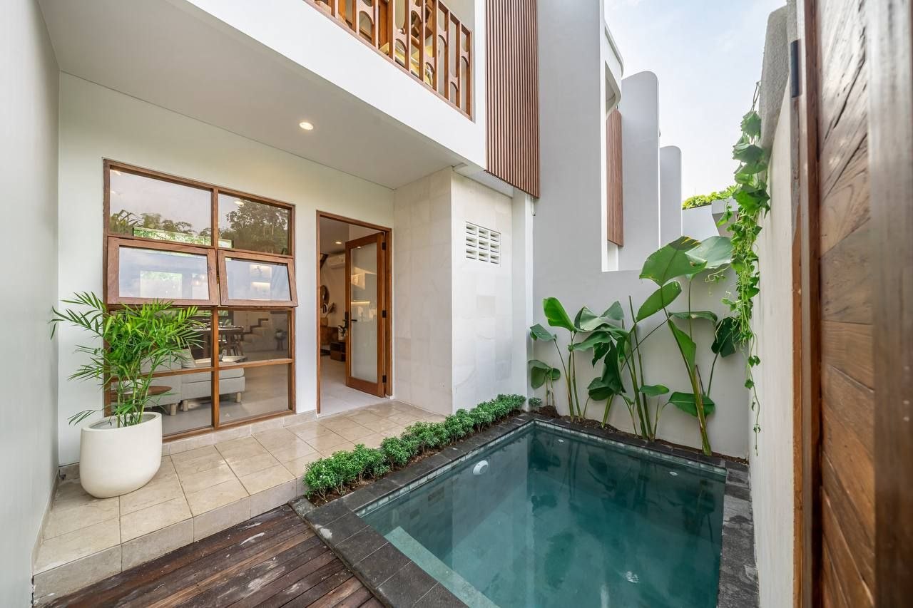 Two-storey villa facade with timber louvres and a private pool