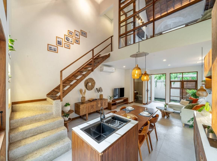 Open-plan kitchen and living room with an island and a staircase under a double-height ceiling